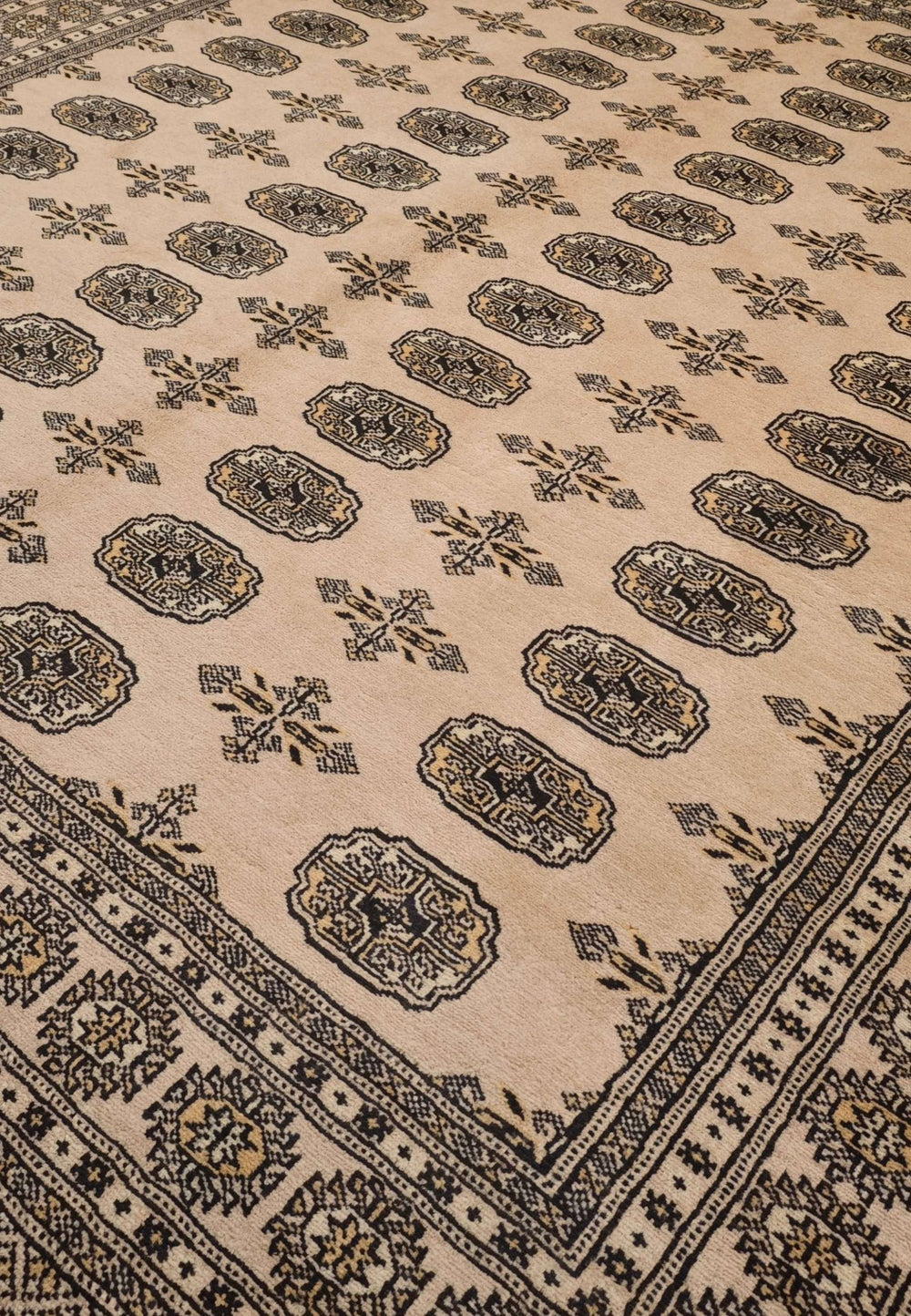 Turkmen gül motifs in camel beige and charcoal on Bokhara rug