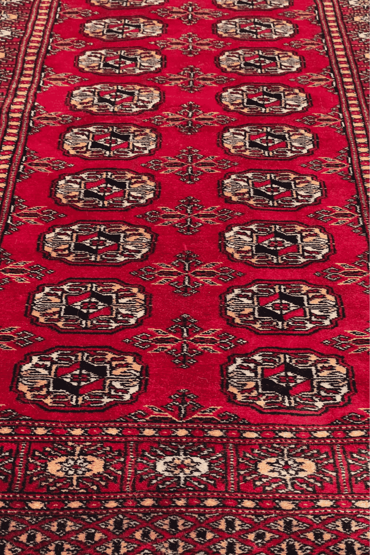 Hand-knotted bright red Bokhara runner with gold Turkmen güls