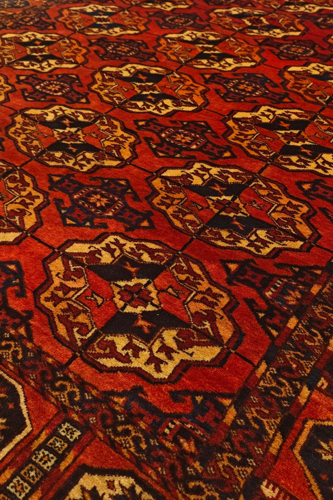 Bokhara gül motifs in burnt orange on Afghan Sherwan rug