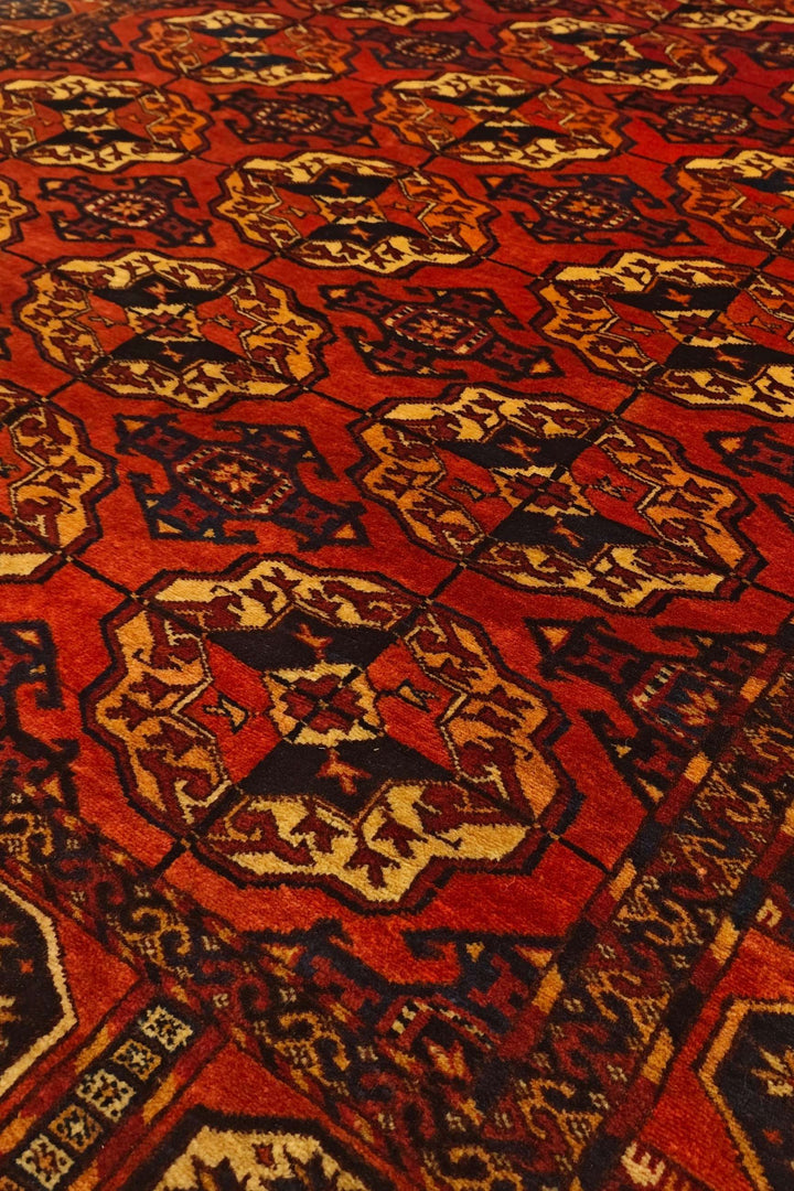 Bokhara gül motifs in burnt orange on Afghan Sherwan rug