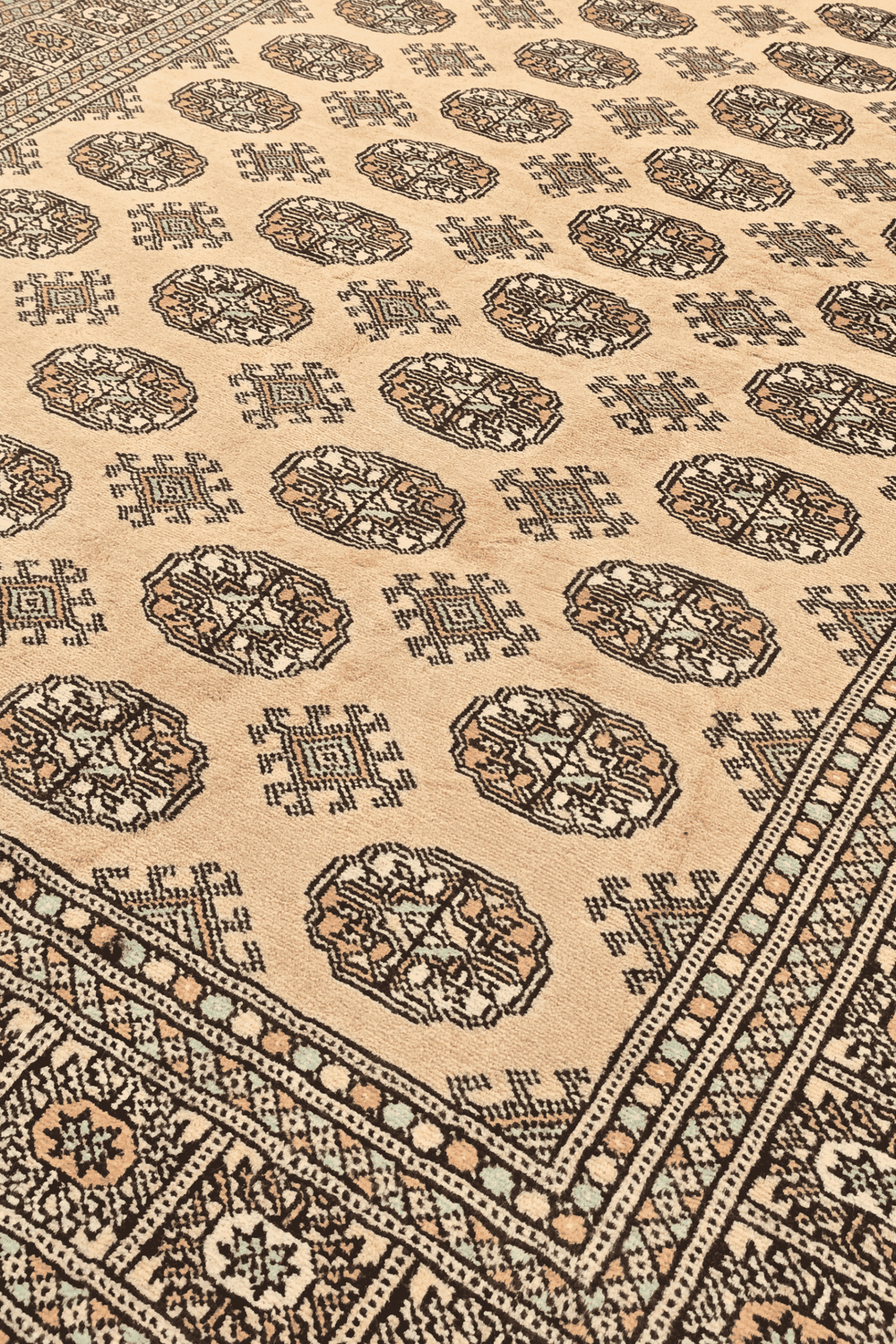 Turkmen gül motifs in warm gold on hand-knotted Bokhara rug