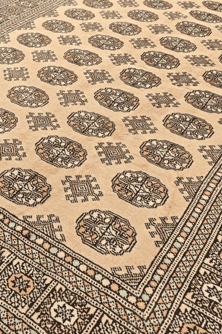 Turkmen gül motifs in warm gold on hand-knotted Bokhara rug