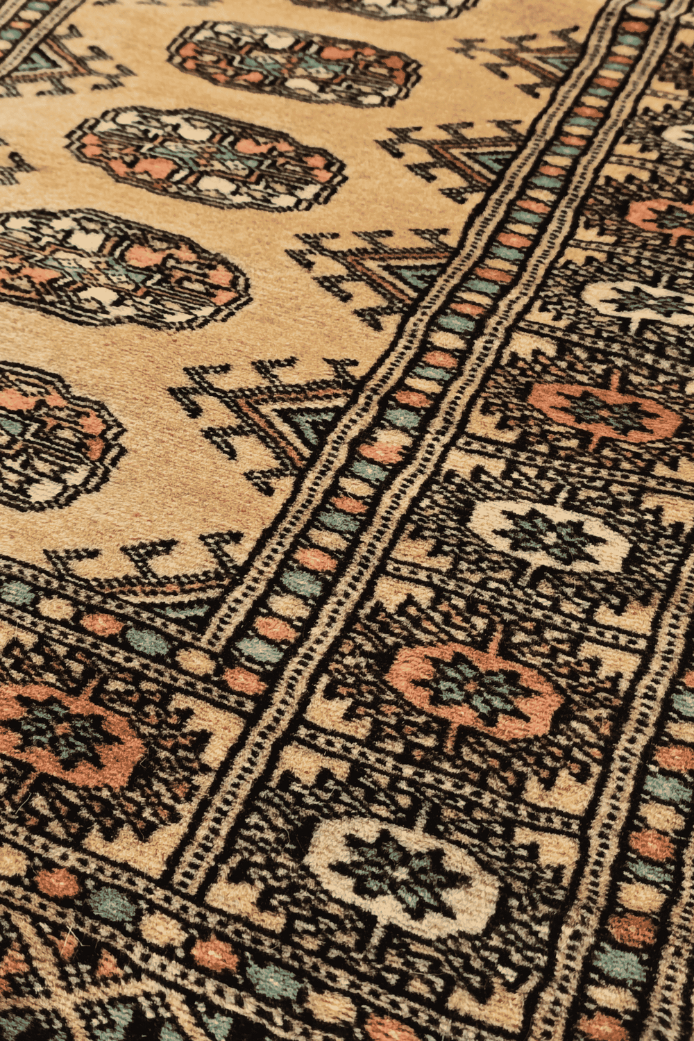 Turkmen gül motifs in gold and peach on small Bokhara rug