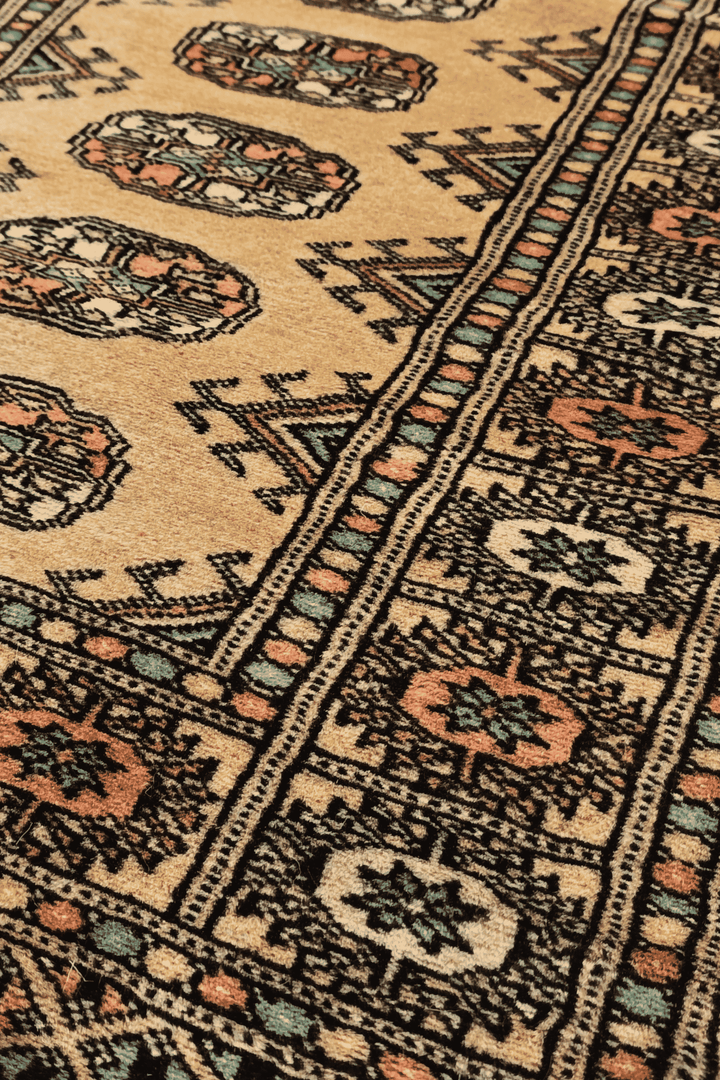 Turkmen gül motifs in gold and peach on small Bokhara rug
