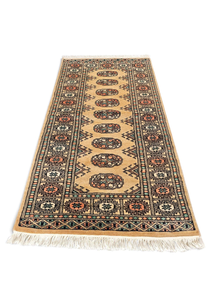 Border detail of gold and peach hand-knotted Bokhara rug