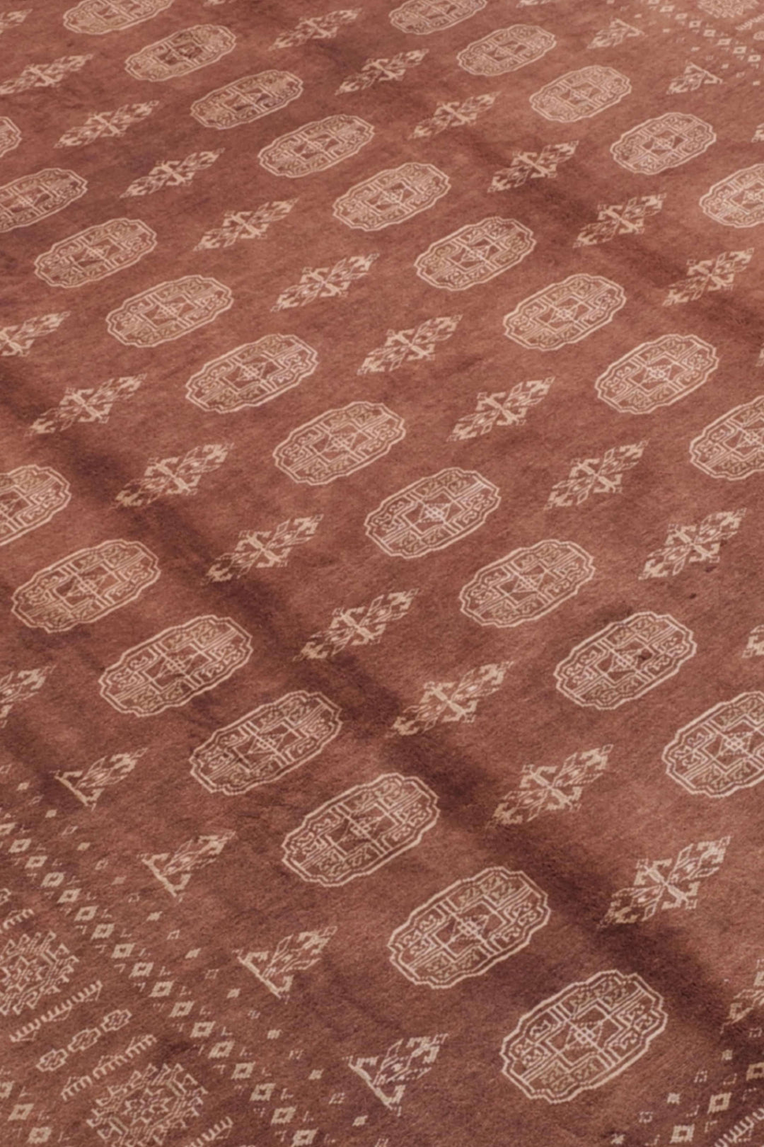 Border detail of chestnut brown hand-knotted Bokhara rug