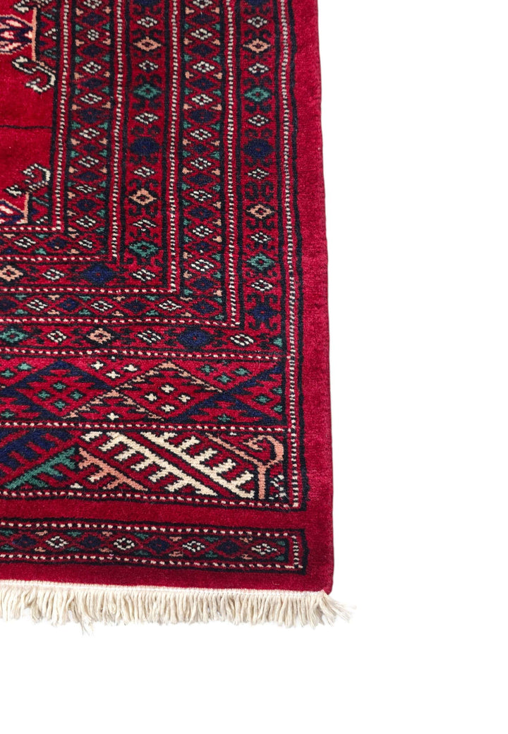 Single column of six Turkmen güls on crimson hand-knotted wool rug