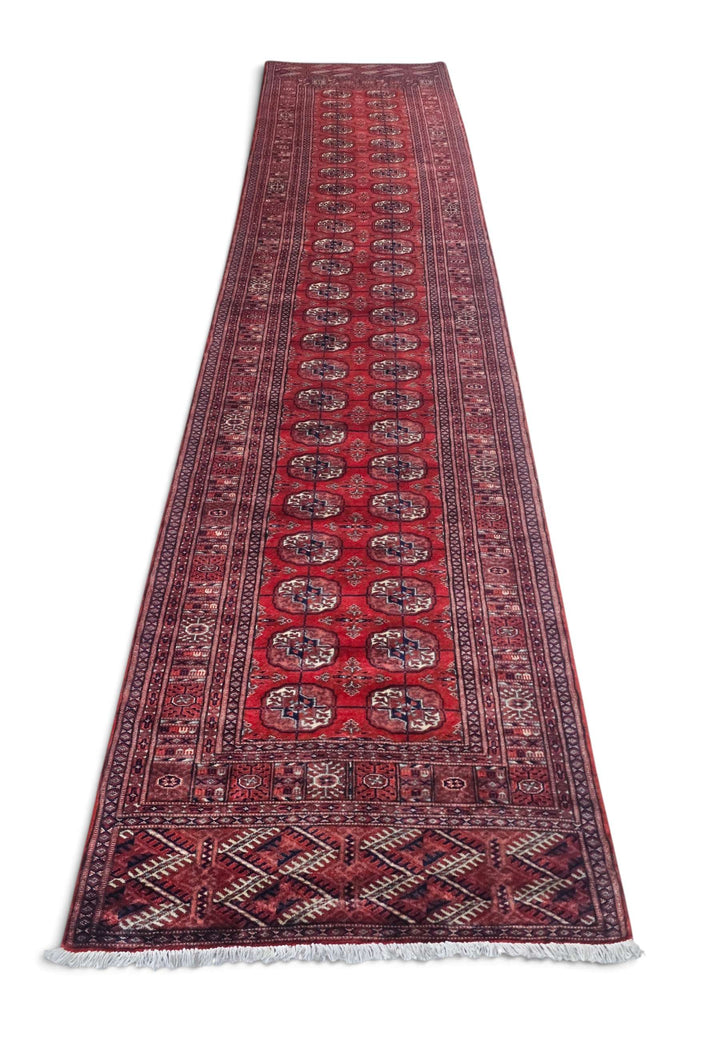 Border detail of deep red hand-knotted Afghan Sherwan runner