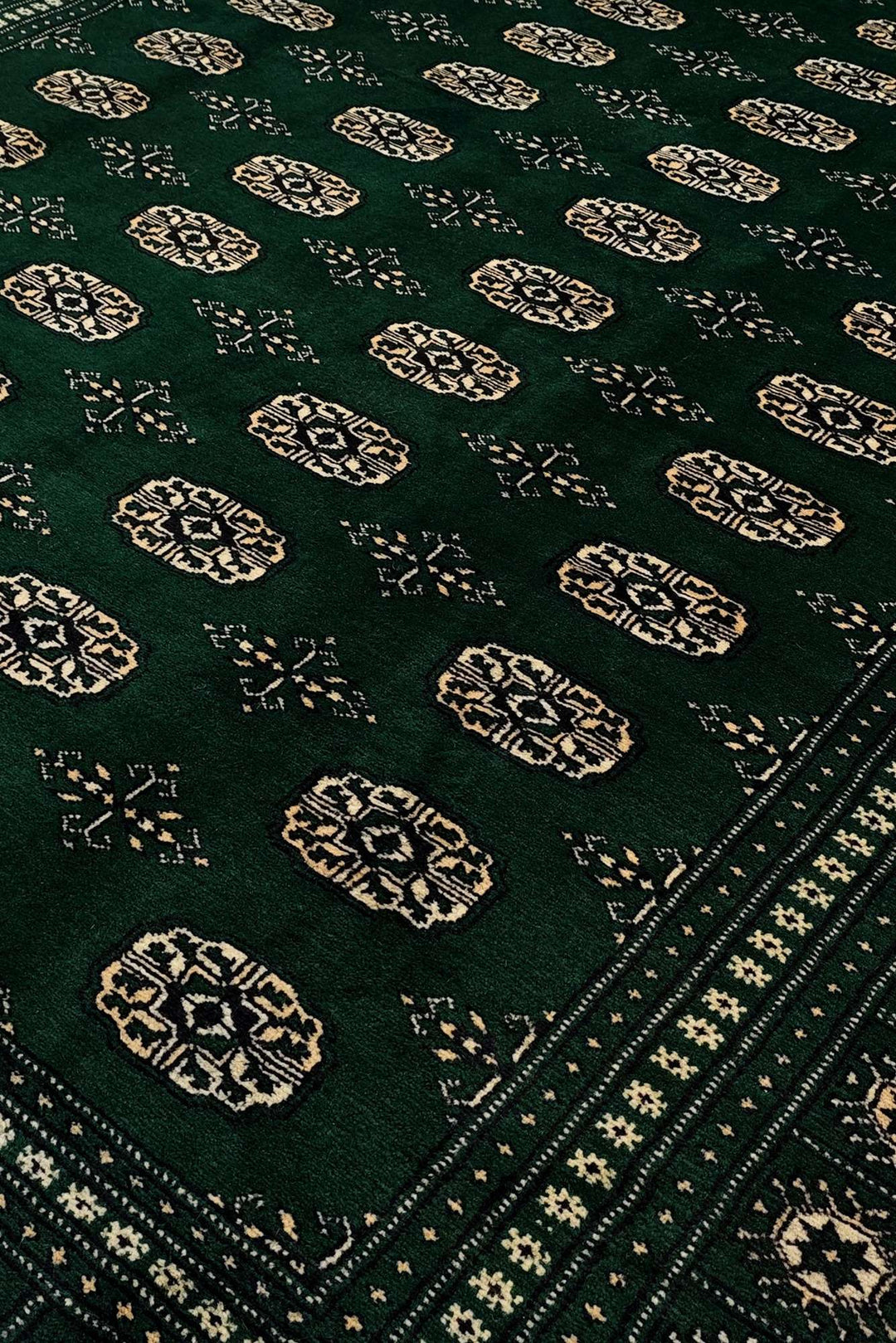 Border detail of forest green hand-knotted Bokhara rug