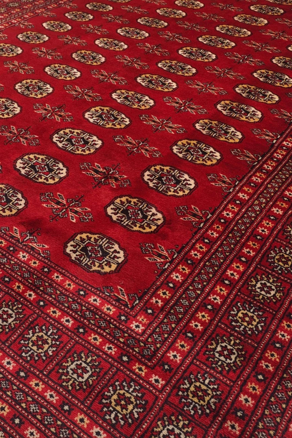 Turkmen gül motifs in madder red and wheat gold on Bokhara rug