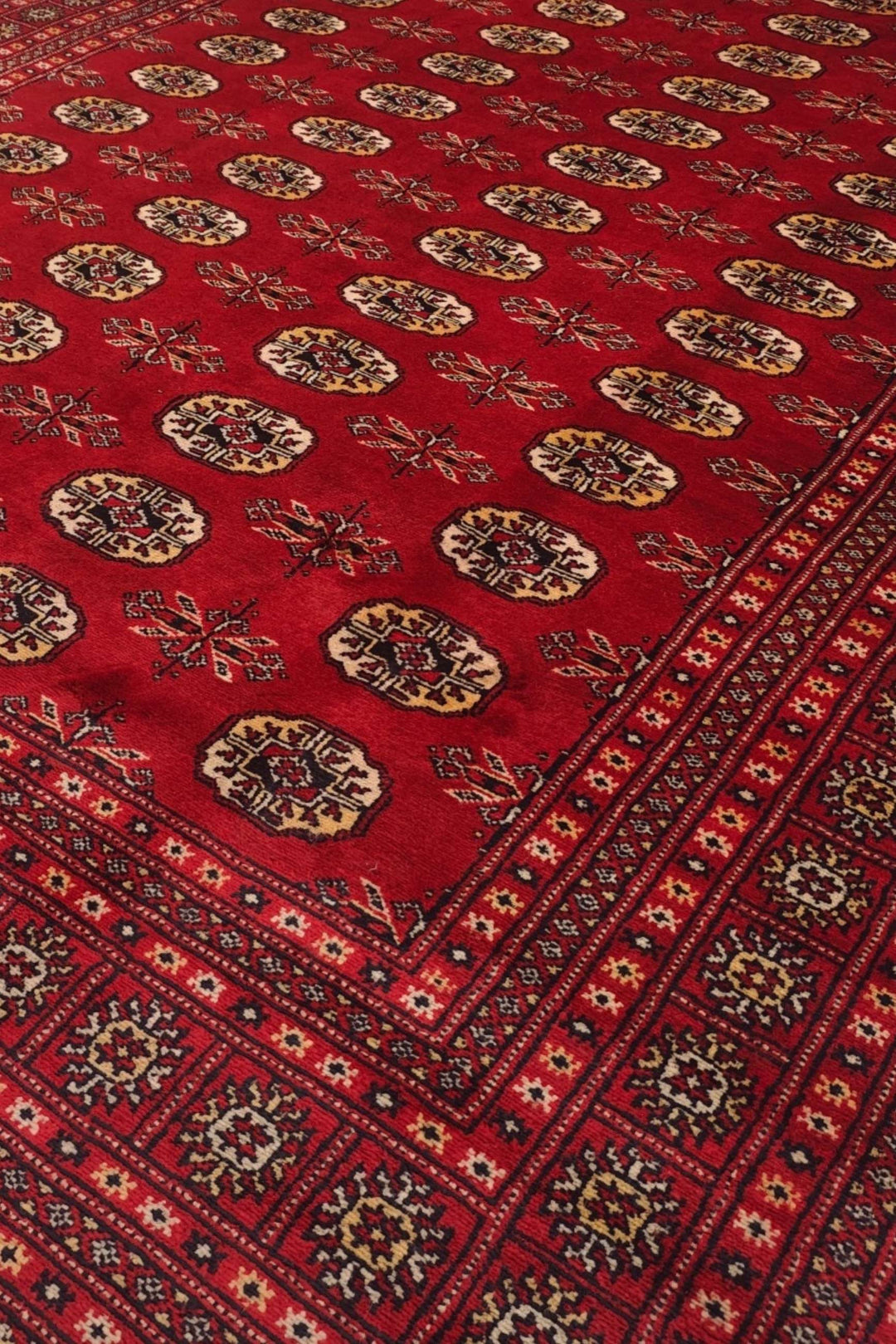 Turkmen gül motifs in madder red and wheat gold on Bokhara rug