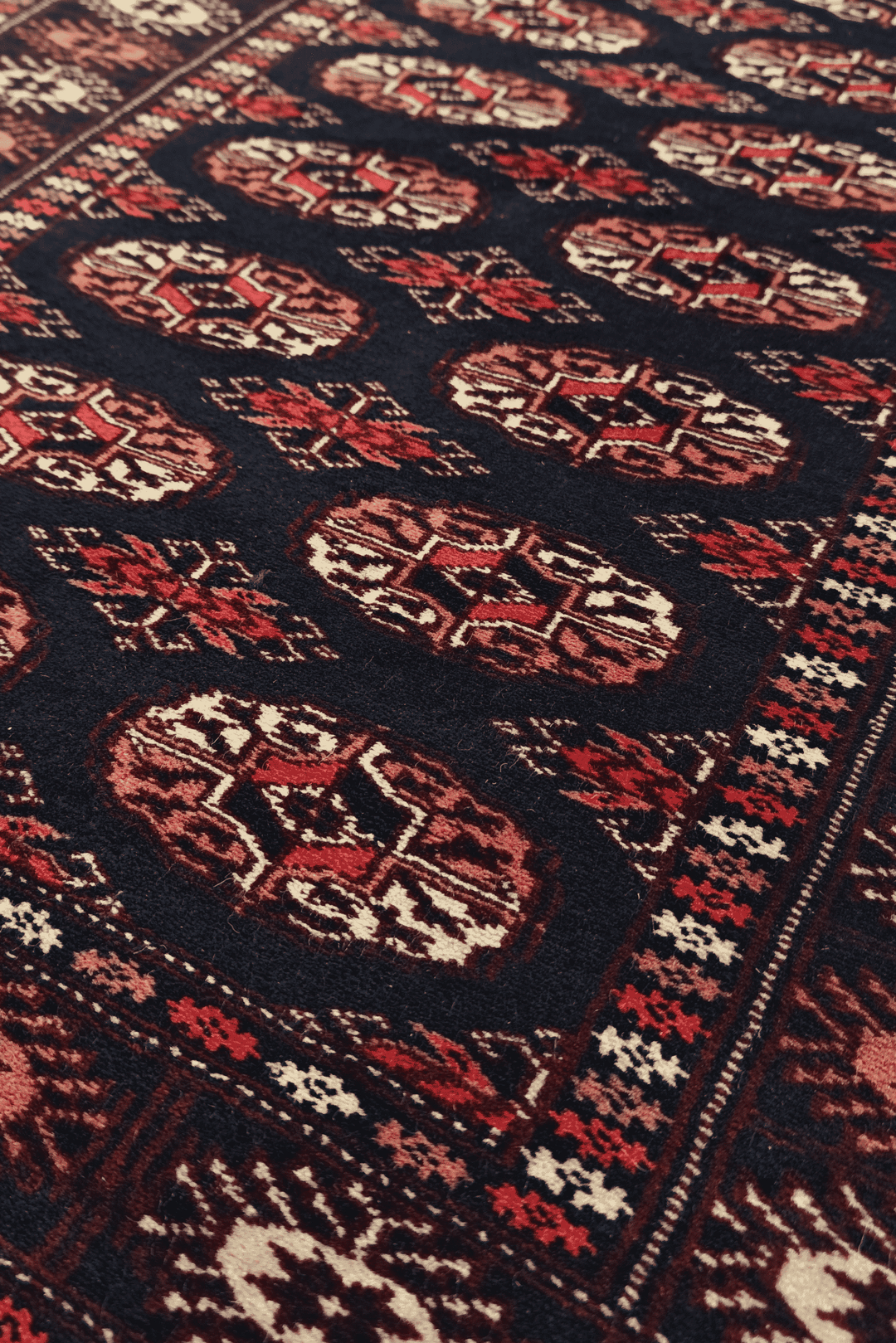 Double column of Turkmen güls in navy and rose on Bokhara runner