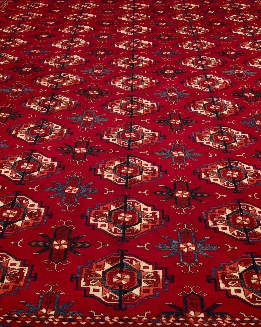 Hand-knotted wool pile of red Turkmen Bokhara Afghan rug