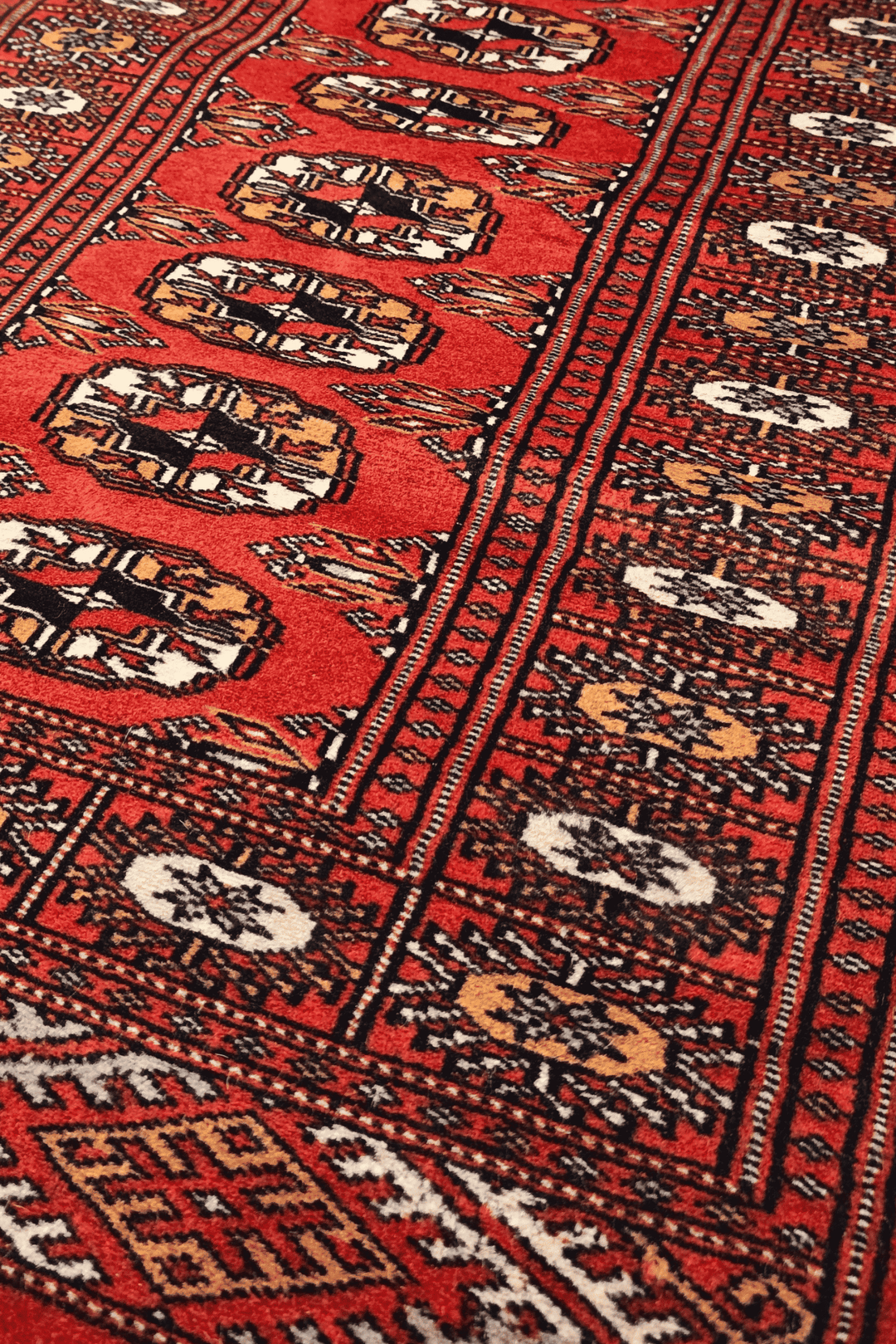 Turkmen gül motifs in red and orange on small Bokhara rug