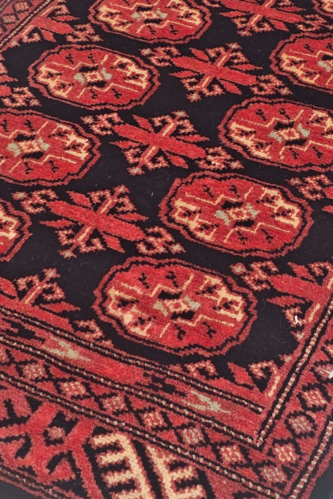 Turkmen gül motifs in espresso and brick red on small Bokhara rug