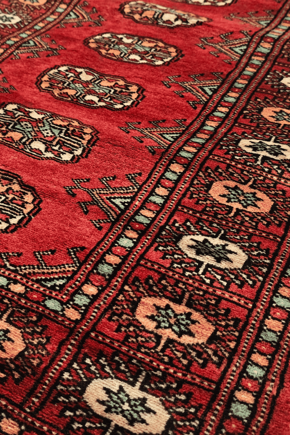 Turkmen gül motifs in red and salmon on small Bokhara rug
