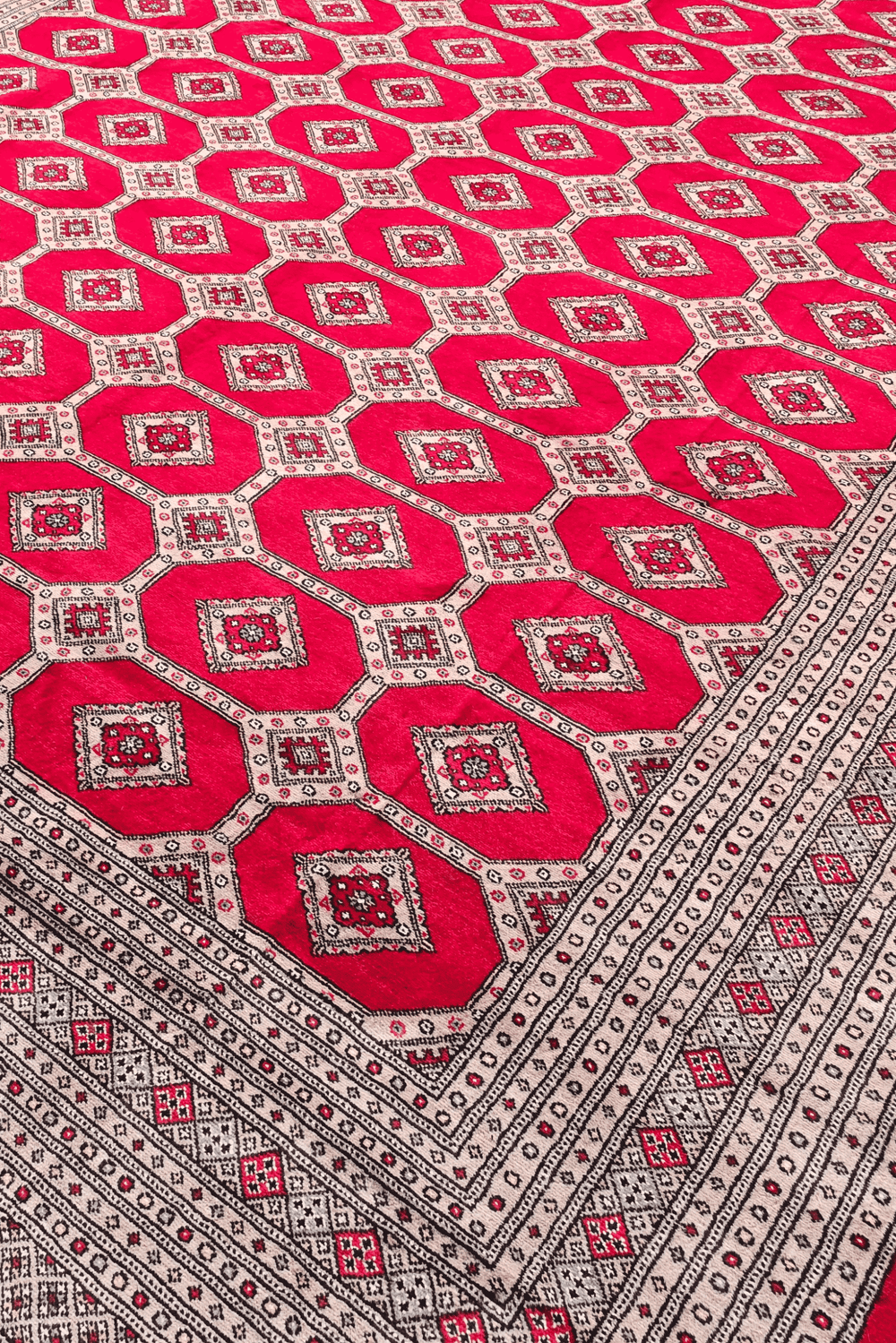 Diamond lattice detail on ruby red Pakistani Bokhara wool rug