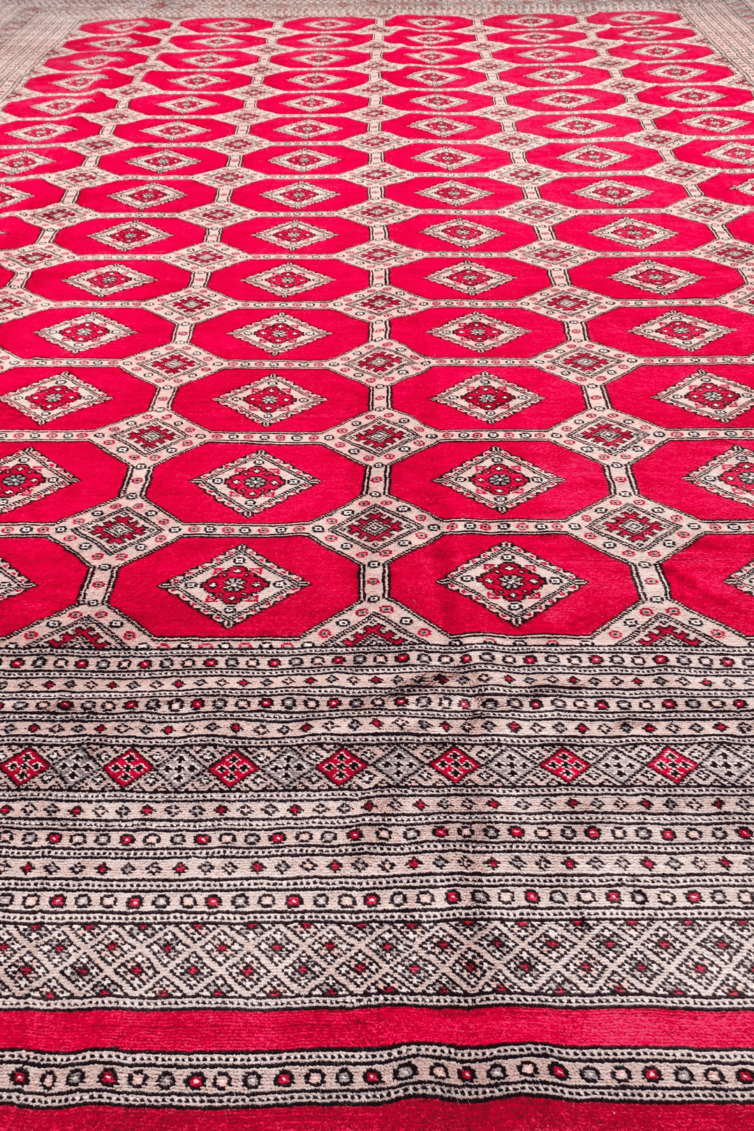 Hand-knotted ruby red Bokhara rug with diamond lattice field