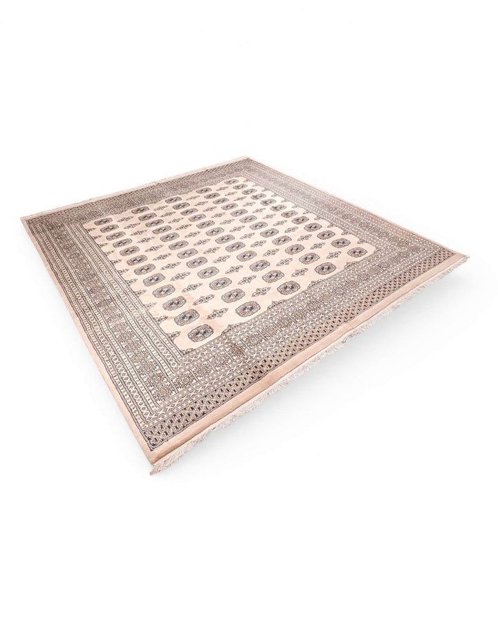 Corner of warm beige Pakistani Bokhara hand-knotted rug