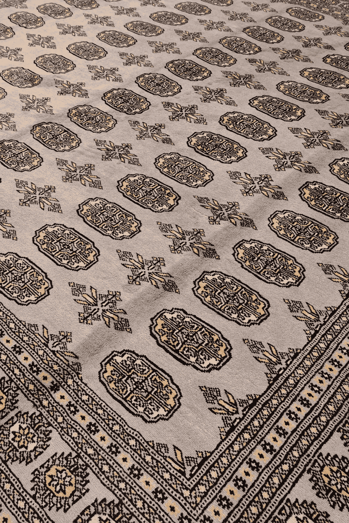 Border detail of warm grey hand-knotted square Bokhara rug