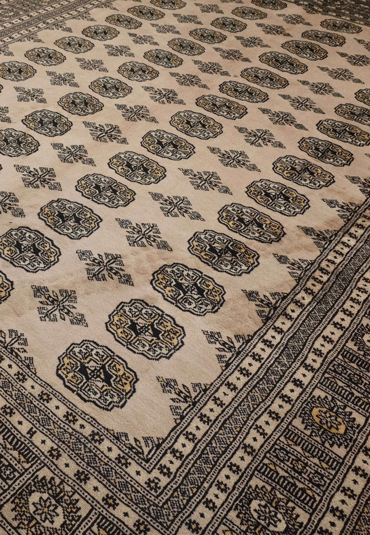 Turkmen gül motifs in warm sand and charcoal on Bokhara rug