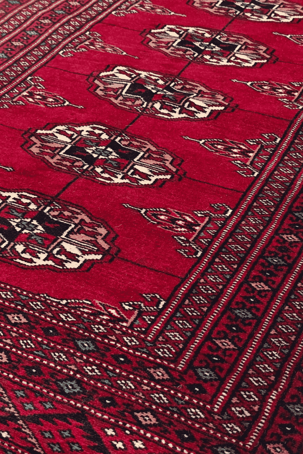 Threaded gül motifs in wine red and cream on Bokhara rug