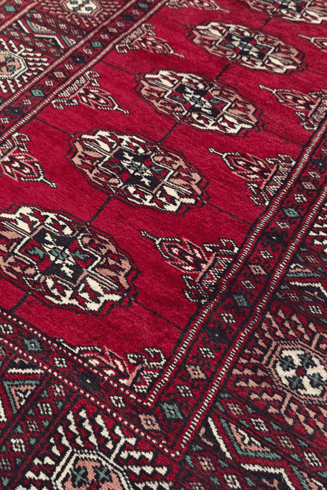 Single column of Turkmen güls in wine red and cream on Bokhara runner