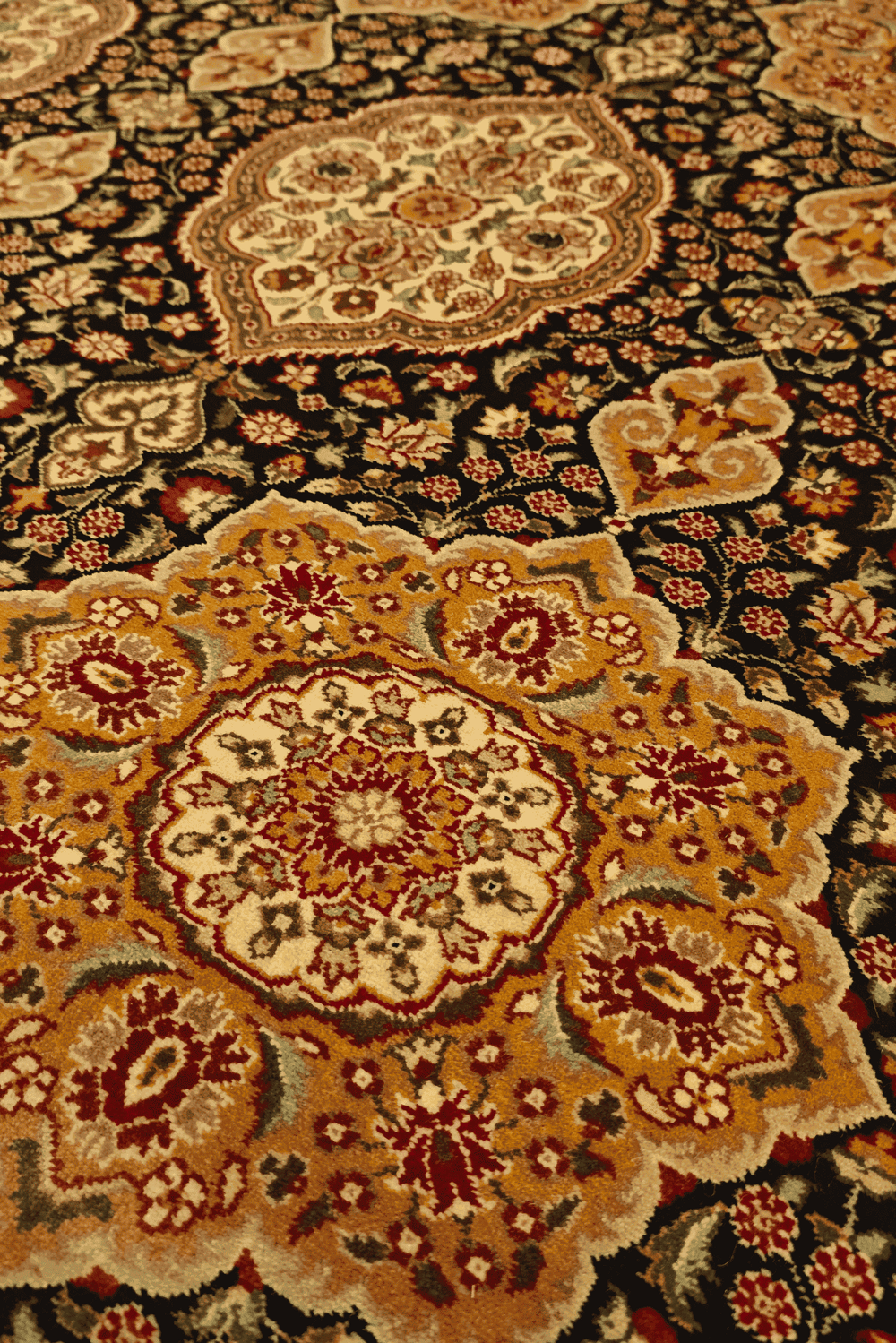 Star medallion detail in gold on Tabriz Pakistani rug