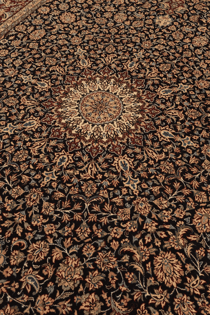 Medallion detail in obsidian and claret on Tabriz rug