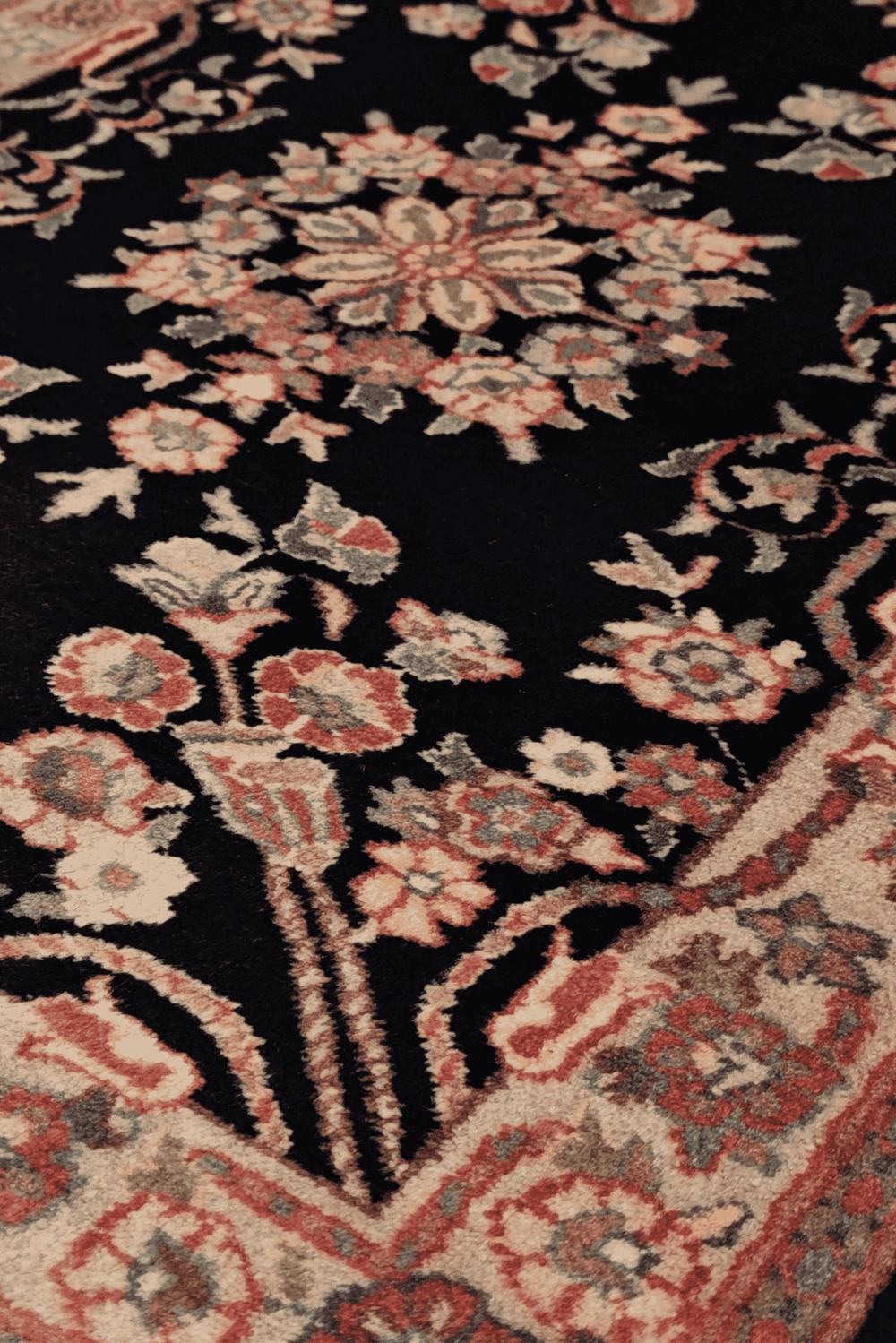 Kashan floral medallion detail in black and cream on rug
