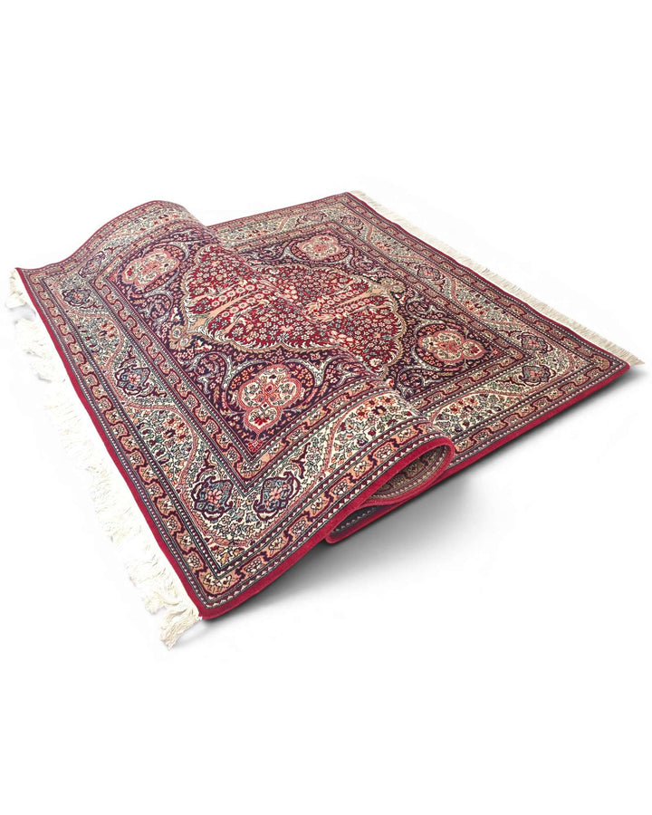 Corner of ruby red Tabriz Pakistani double-knot rug