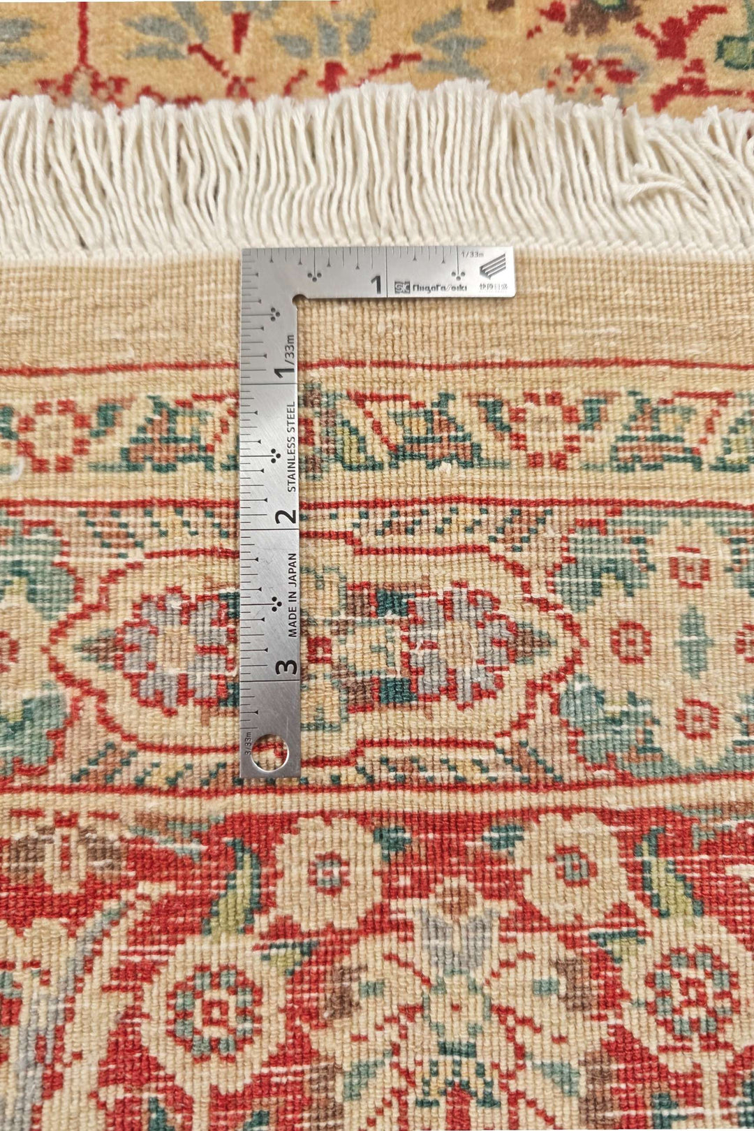 Corner of cream red Tabriz Pakistani double-knot rug