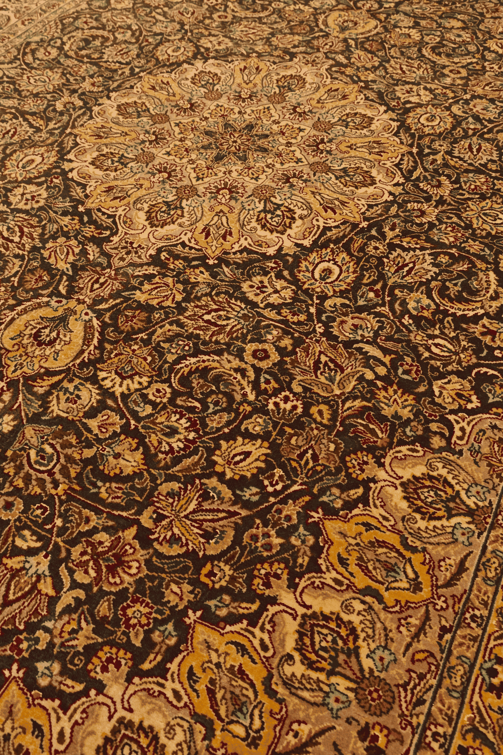 Medallion detail in espresso brown and gold on Tabriz rug