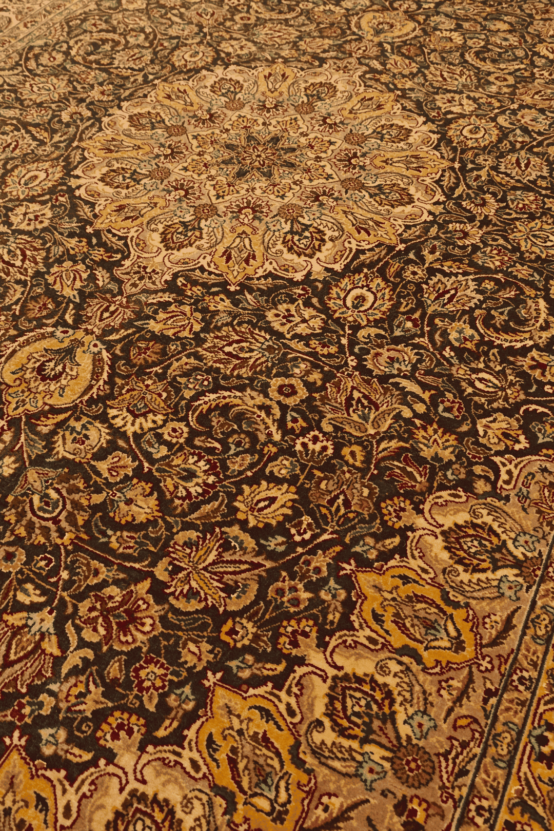 Medallion detail in espresso brown and gold on Tabriz rug
