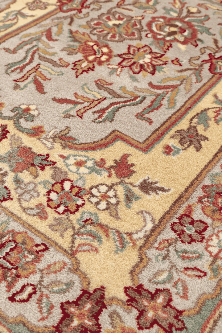 Aubusson style floral panel in gold and grey on hand-knotted rug