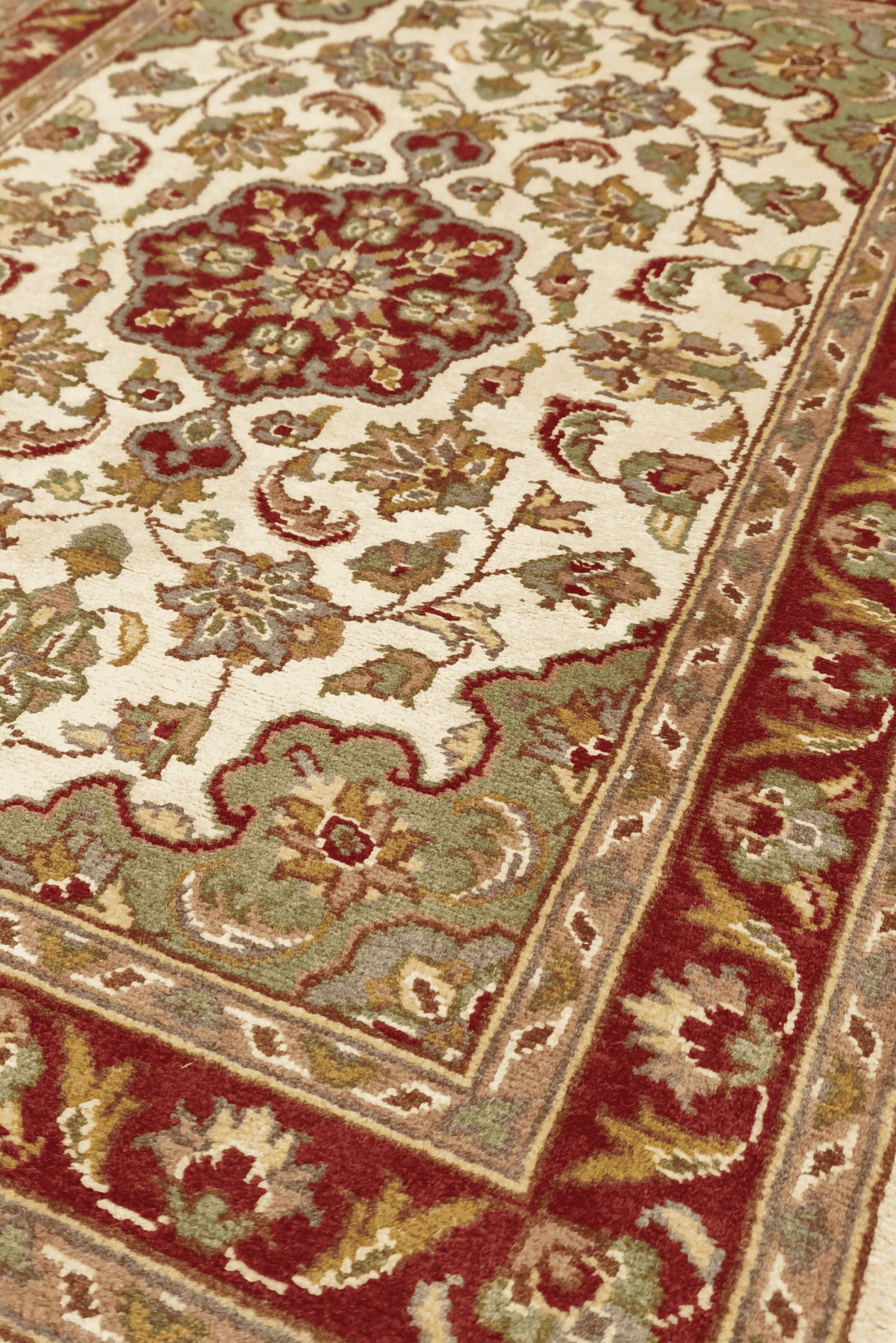 Medallion detail in ivory and deep red on Tabriz rug