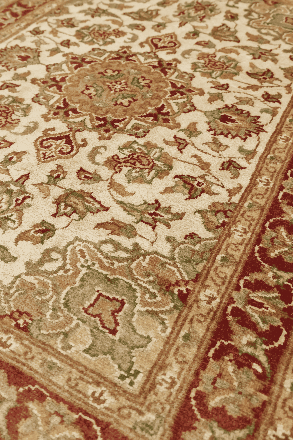 Cloud band medallion detail in ivory and deep red on Tabriz rug