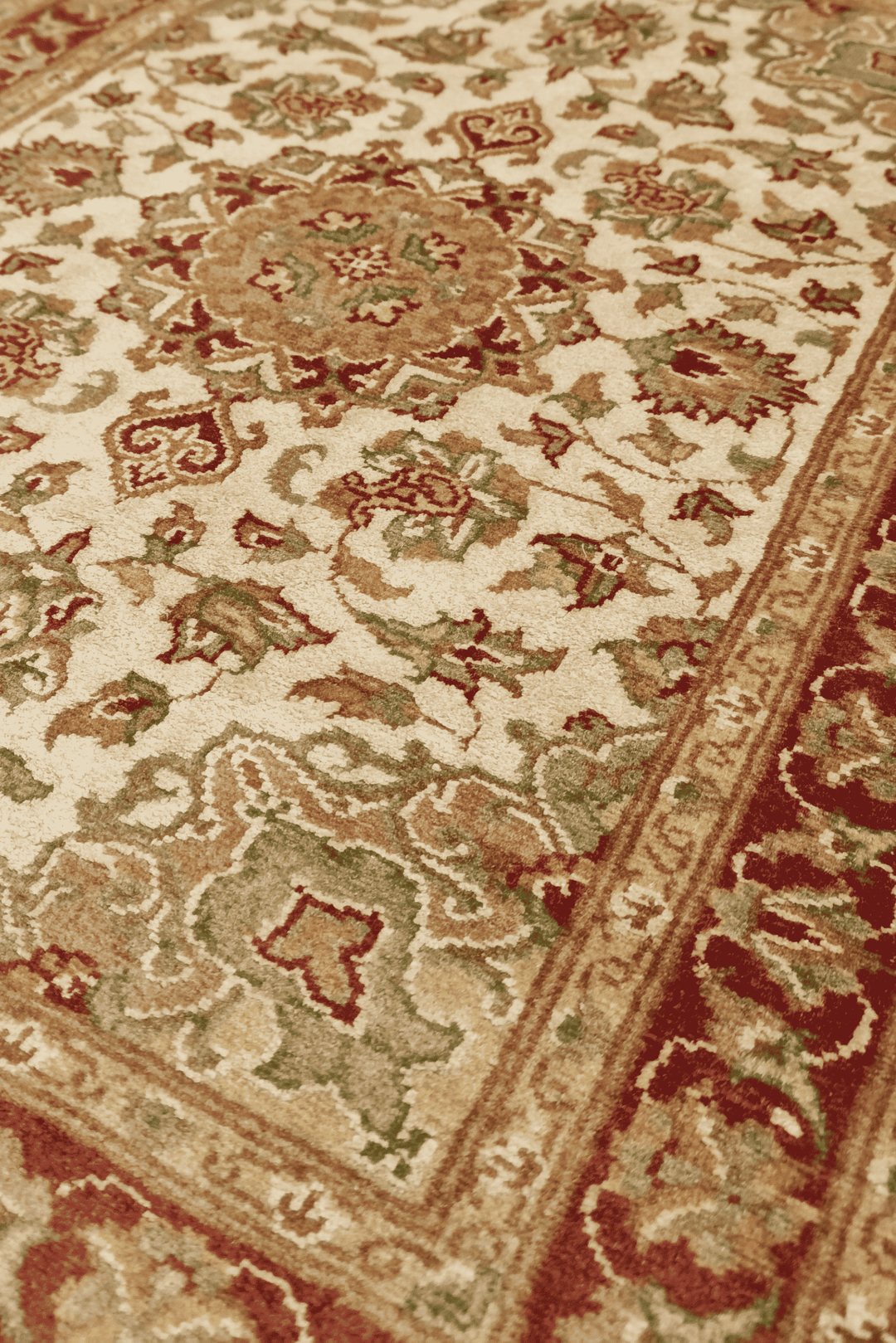 Cloud band medallion detail in ivory and deep red on Tabriz rug
