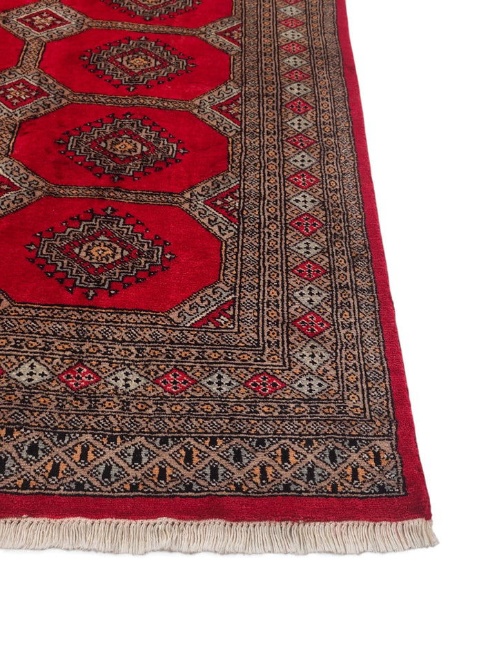 Corner of bright red and sand Jaldar hand-knotted rug