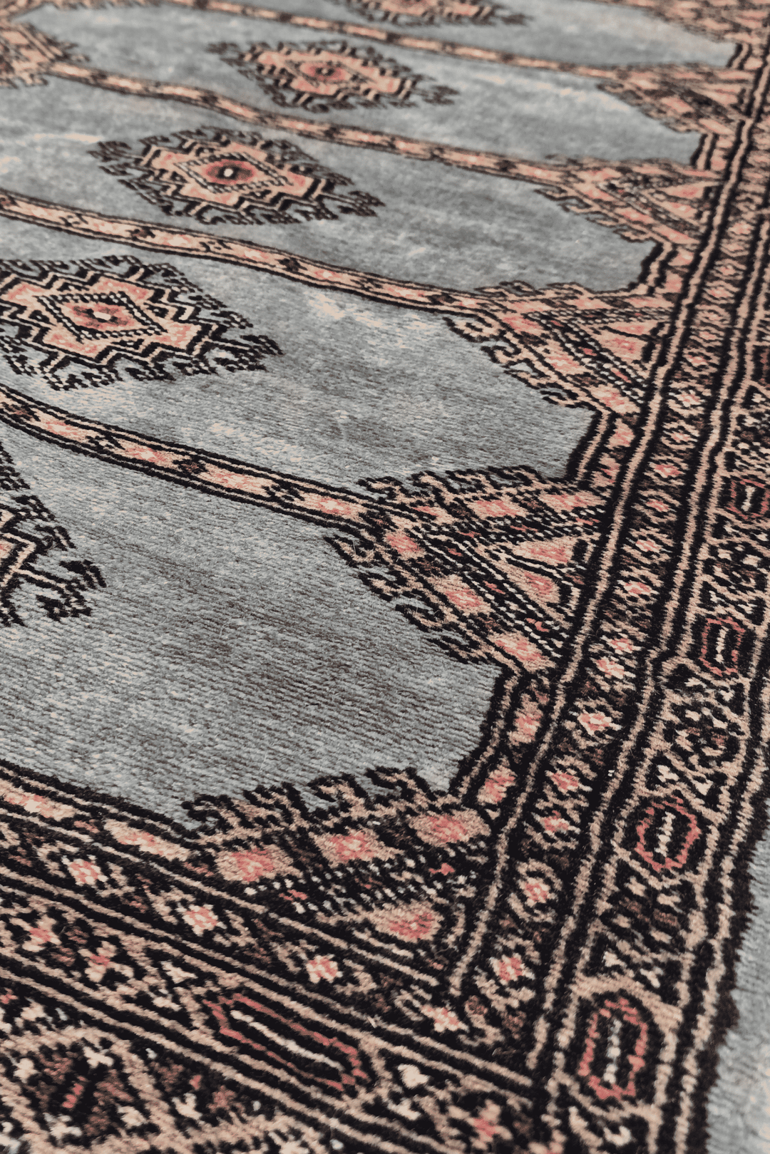 Diamond medallion detail in dusty blue and peach on Jaldar rug