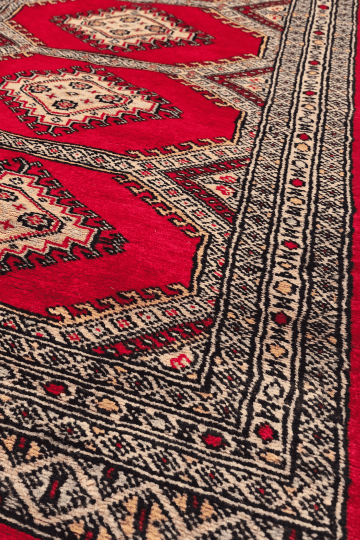Stepped diamond gül motifs in ruby red on Jaldar rug
