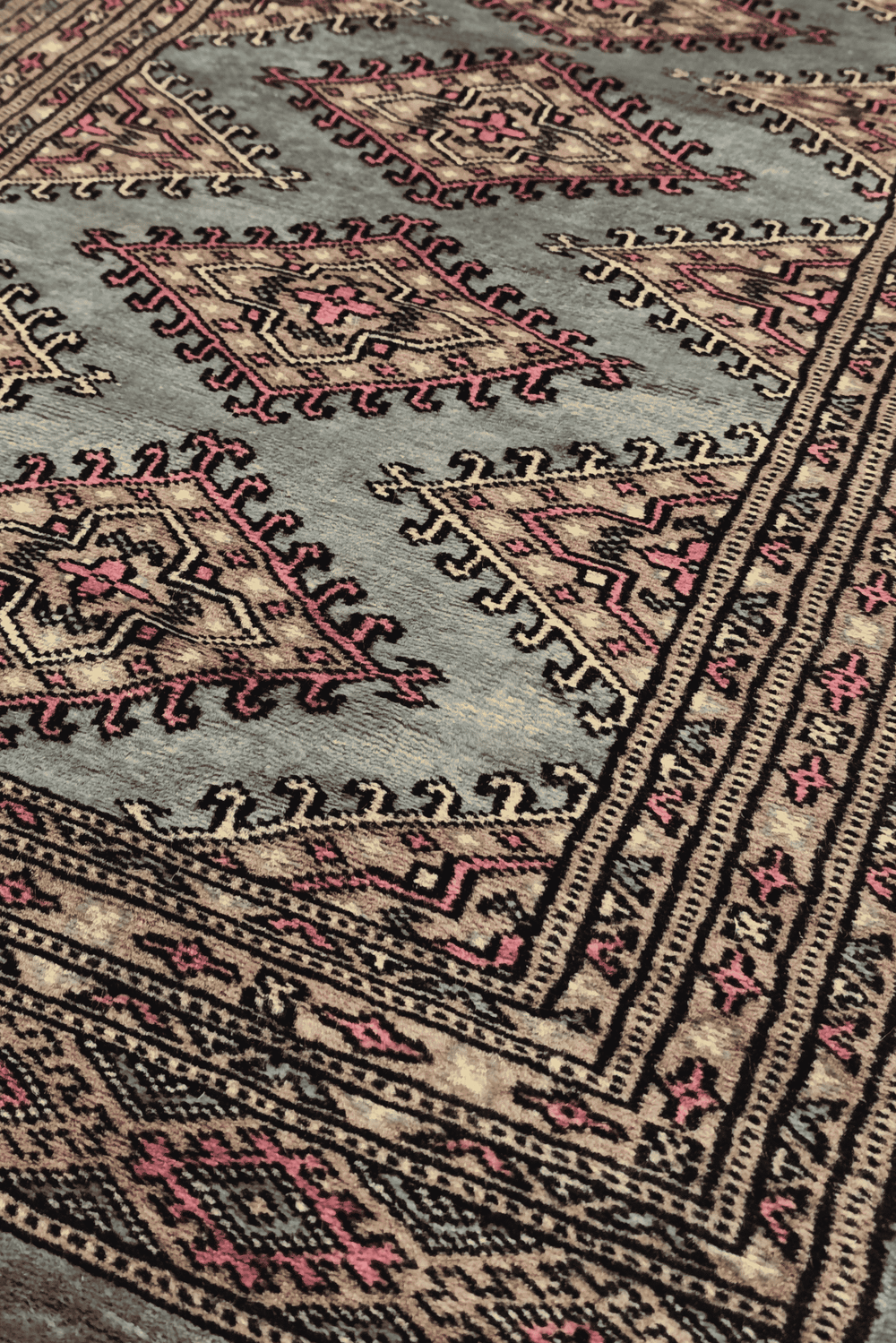 Diamond medallion detail in grey-green and rose on Jaldar rug