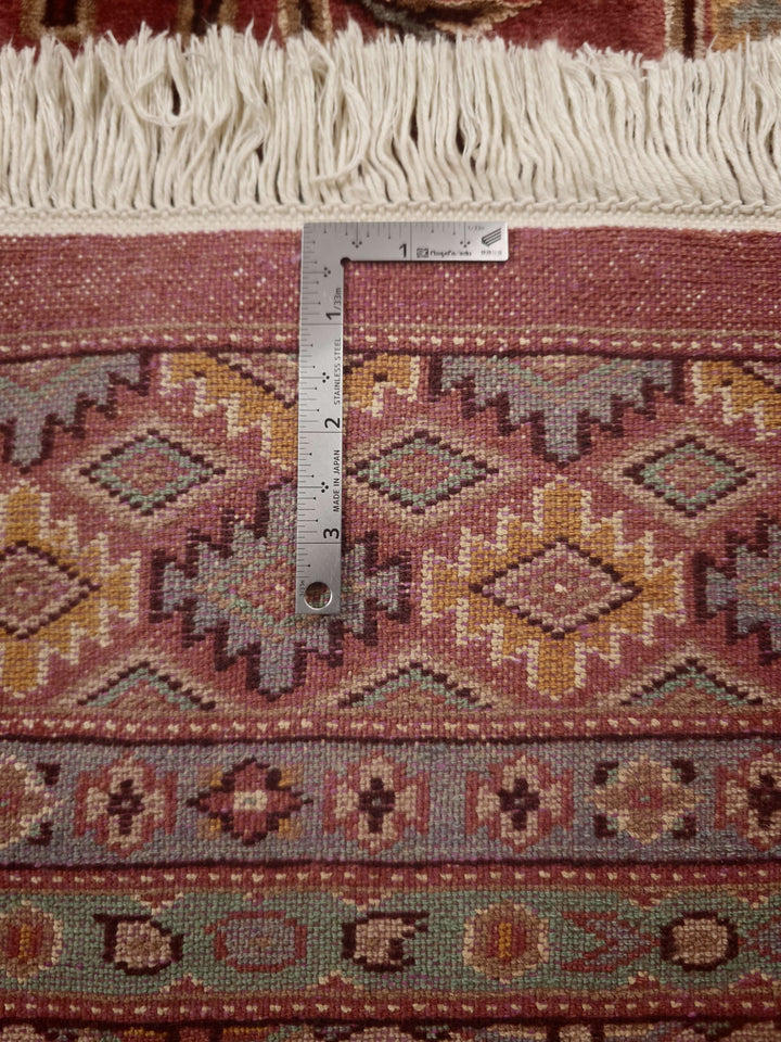Corner of rust red and green Jaldar hand-knotted rug