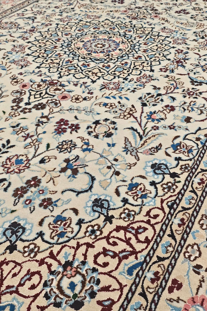 Medallion detail in ivory and wine red on Persian Nain rug