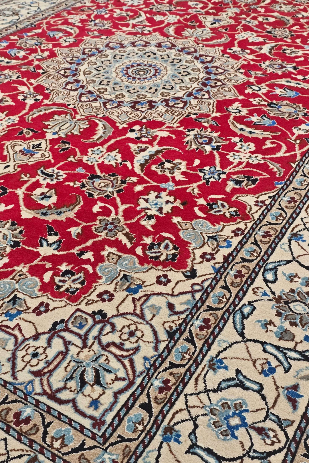 Medallion detail in red and ivory on Persian Nain rug