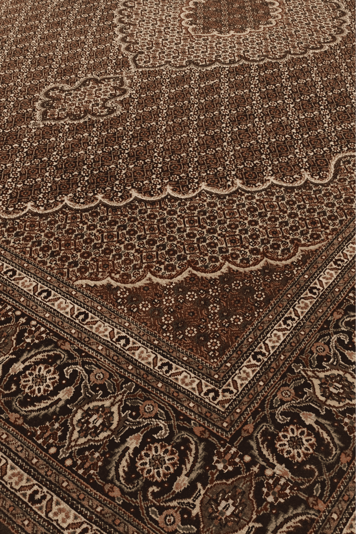 Border detail of brown mahi Tabriz hand-knotted rug