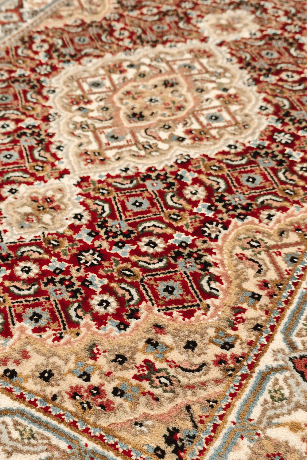 Mahi medallion detail in brick red and sandstone on Tabriz rug