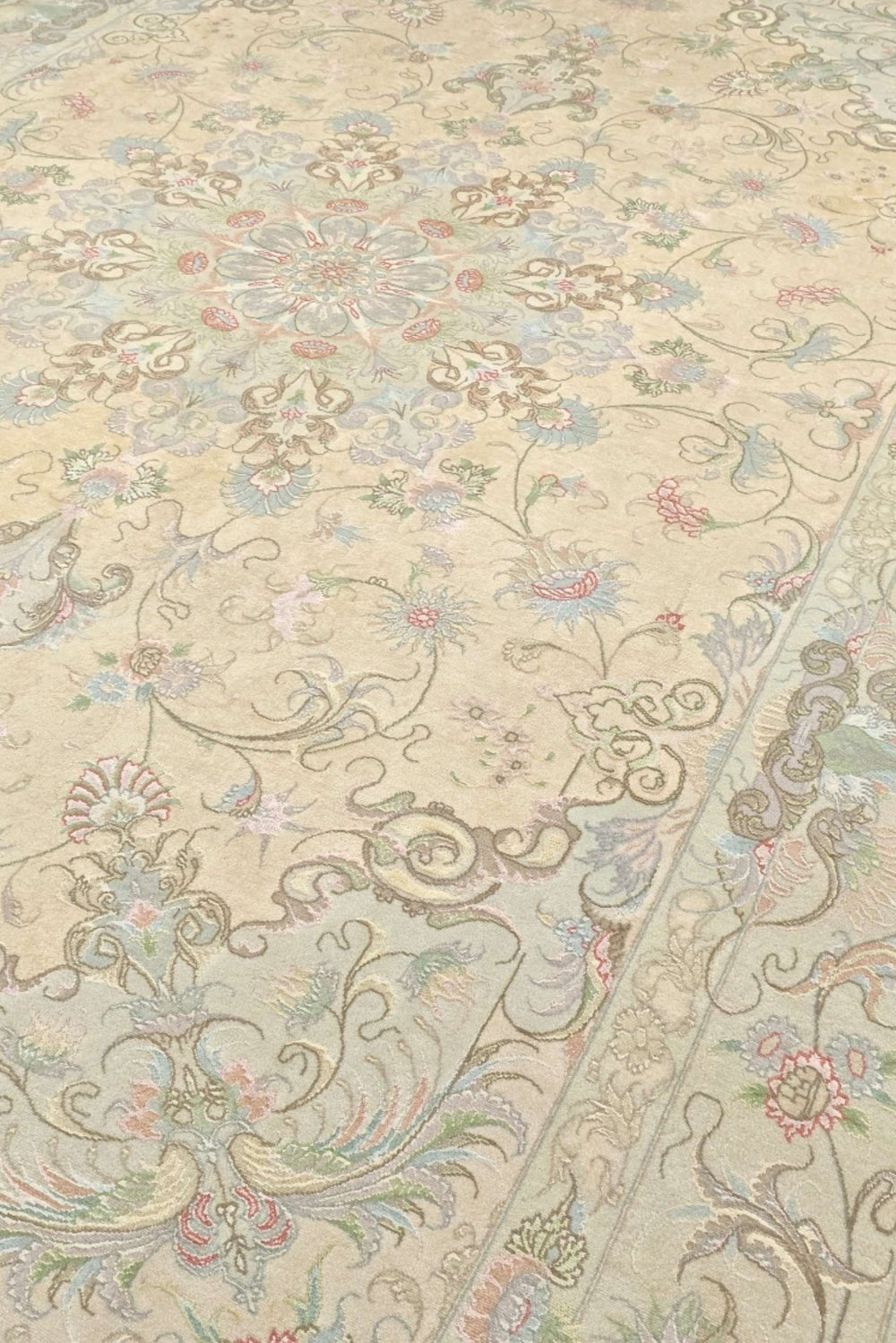 Medallion detail in cream and soft pink on Tabriz rug