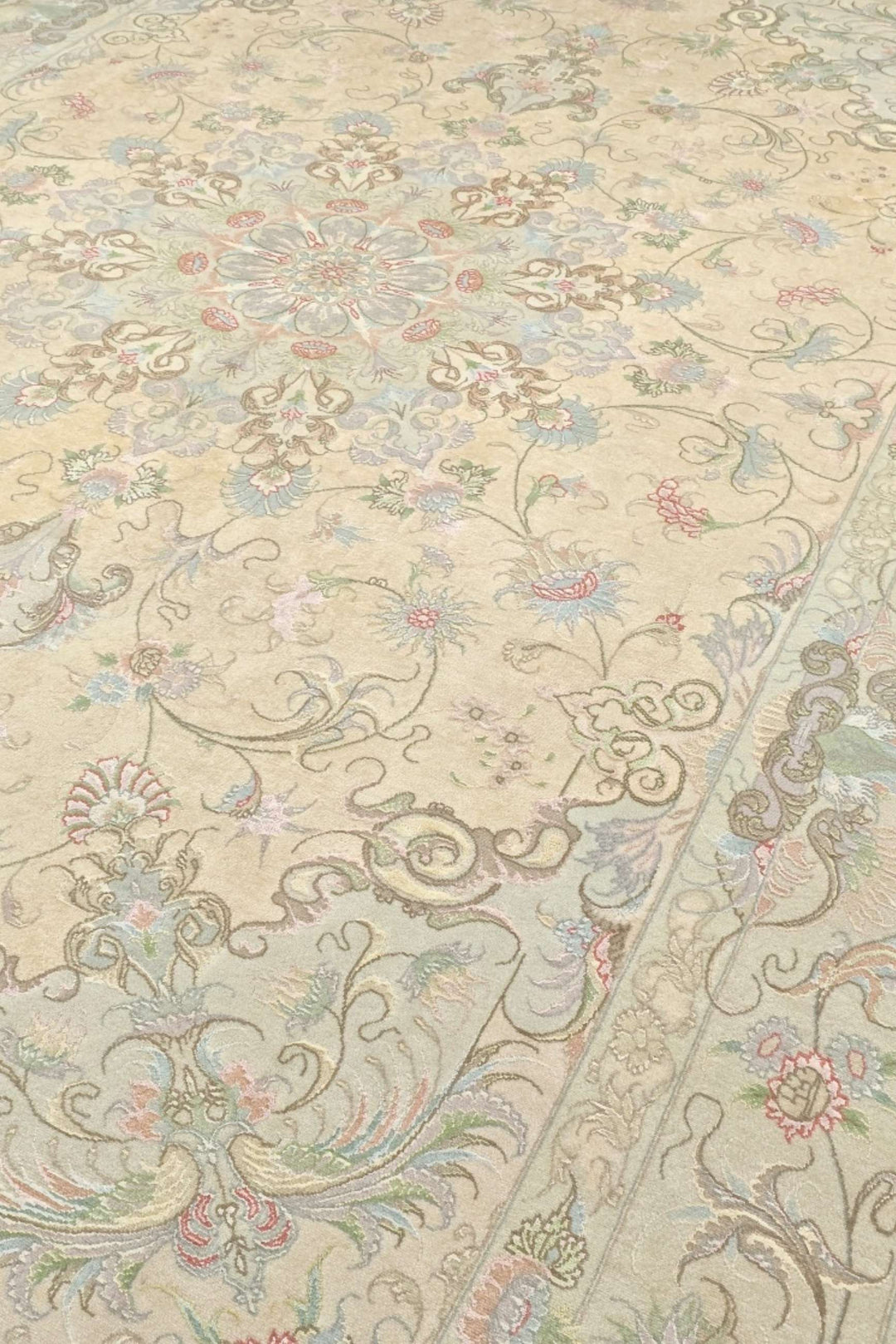 Medallion detail in cream and soft pink on Tabriz rug