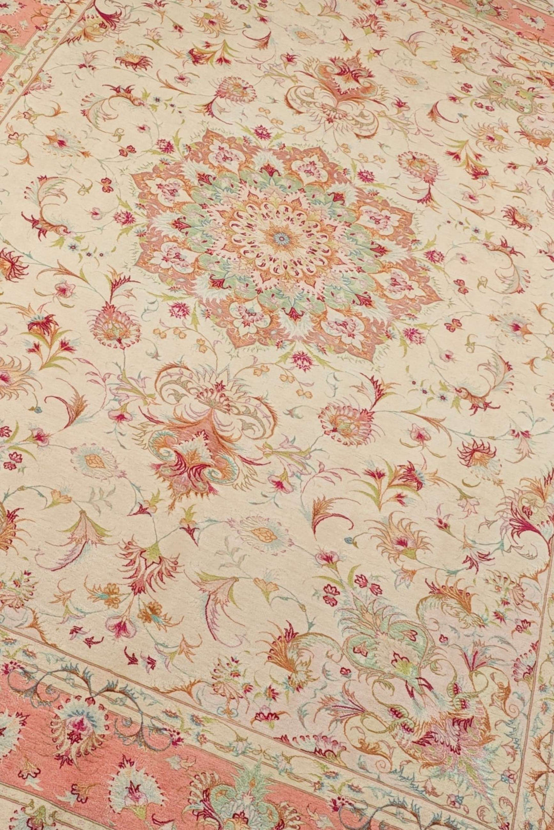 Medallion detail in cream and coral on Tabriz rug